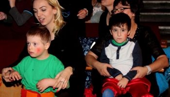 dzieci z opiekunami siedzące na widowni