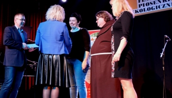 prezes spółki komunalnej, zastępca burmistrza i franciszanin na scenie wręczają nagrody