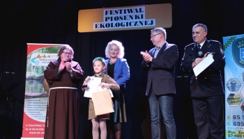 prezes spółki komunalnej, zastępca burmistrza i franciszanin na scenie wręczają nagrody