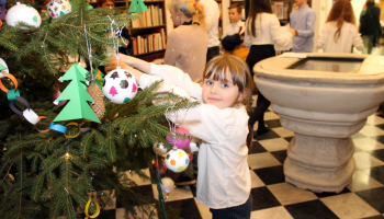 dzieci wieszają ozdoby na choince