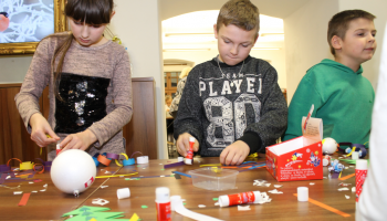 dzieci wykonują ozdoby choinkowe