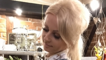 Pani Szyszka z bukietem kwiatów w swojej kwiaciarni