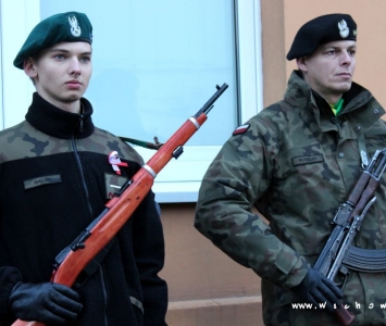 dwóch mundurowych przy pamiątkowej tablicy