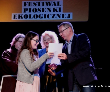 prezes spółki komunalnej, zastępca burmistrza i franciszanin na scenie wręczają nagrody